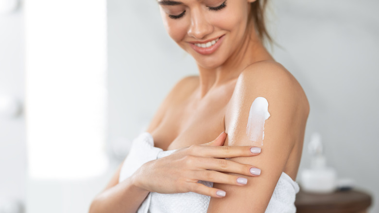 Woman applying moisturizer