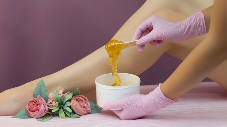 Woman holding tub of wax