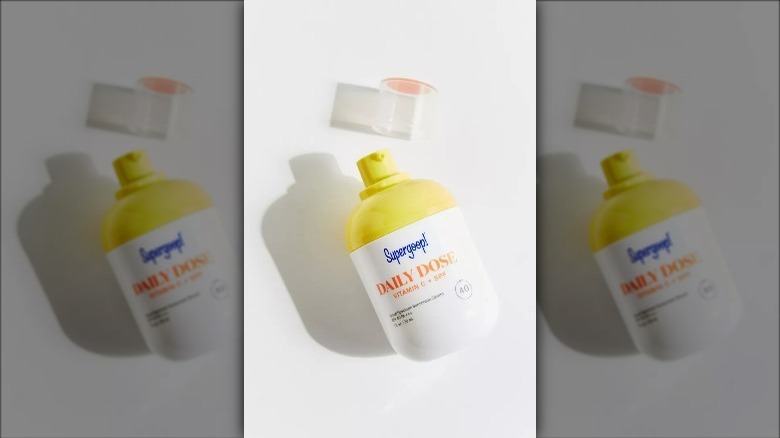 Bottle of Supergoop Vitamin C SPF Serum on white background with lid taken off