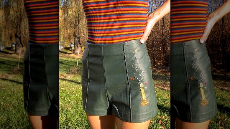 Person wearing embroidered leather shorts