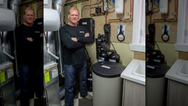 Mike Holmes standing next to pipes