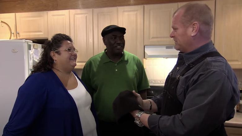 Mike Holmes talking to homeowners in kitchen