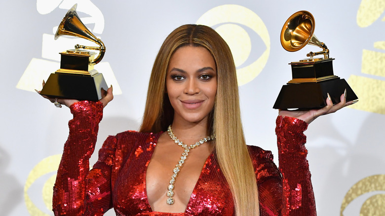 Beyoncé holding up two Grammy awards