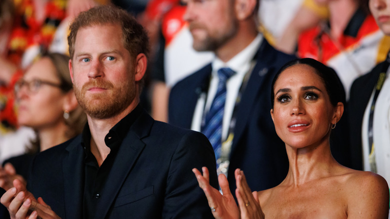 Prince Harry and Meghan Markle clapping in audience