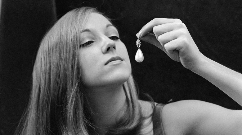 Woman examining the La Peregrina Pearl