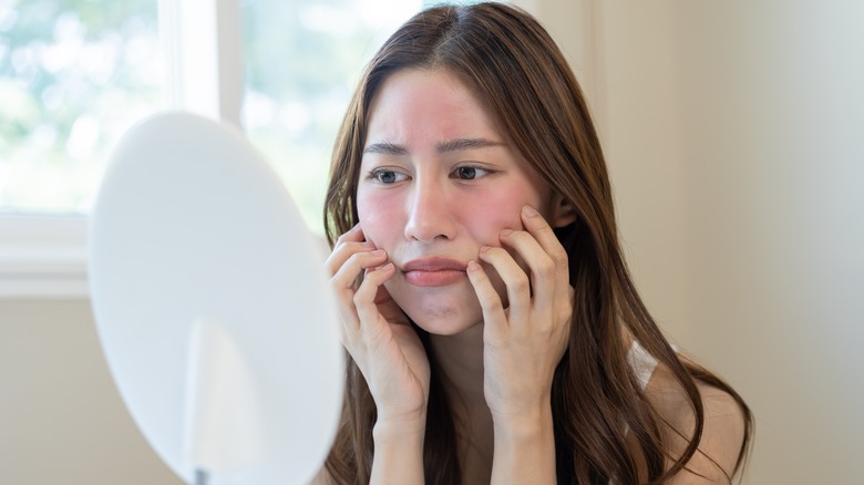 Unhappy woman looking in mirror