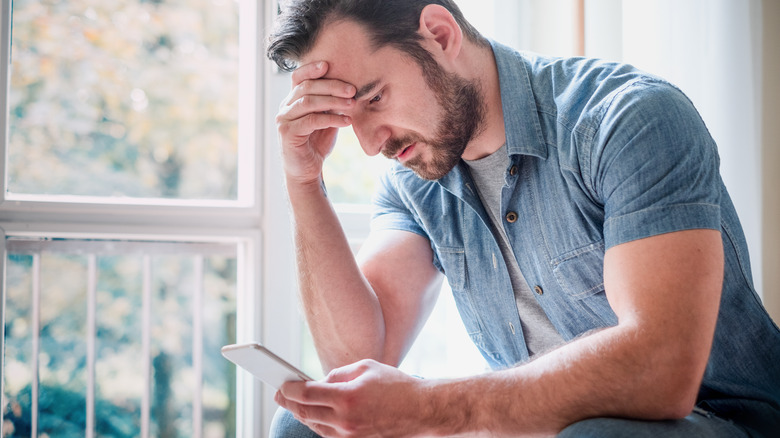 Man looking disappointedly at phone