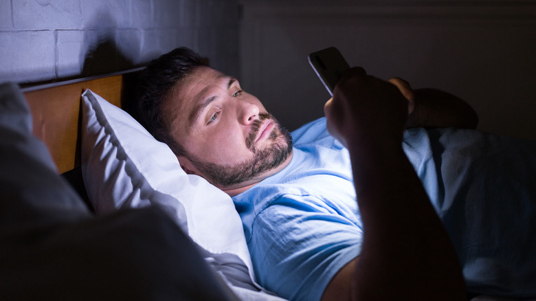 Man texting in bed at night