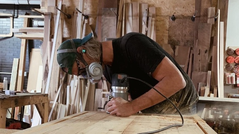 Steve Ford sanding wood in workshop