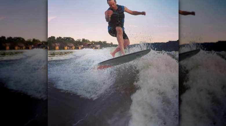 Steve Ford on surfboard in river