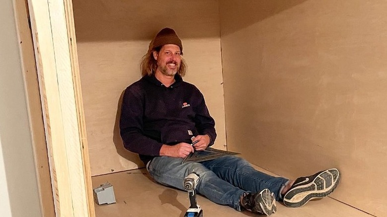 Steve Ford sitting inside wooden box