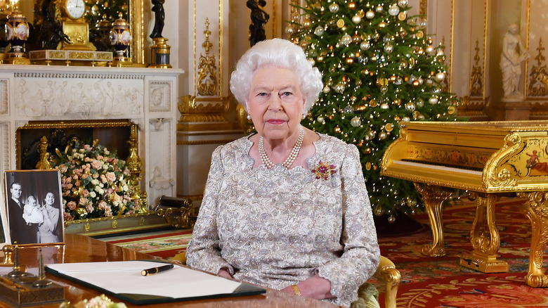 Queen Elizabeth II sitting in front of Christmas tree