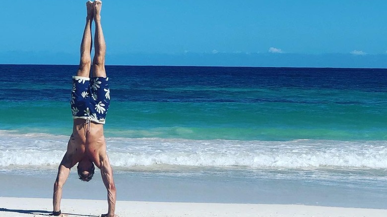 Stephen Huszar doing hanstand on beach