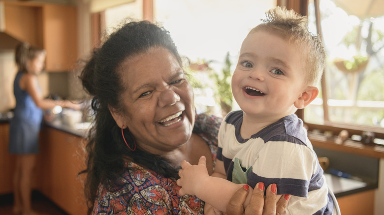 Baby boy laughing with older woman