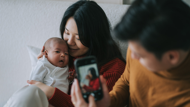 Parents taking a picture of their new baby