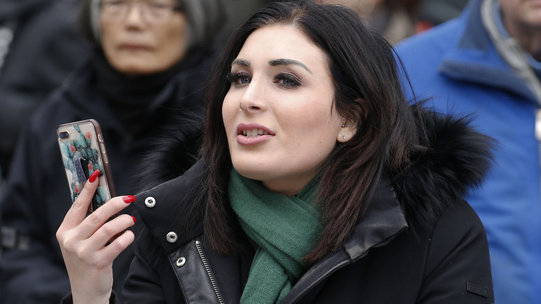 Laura Loomer holding up phone