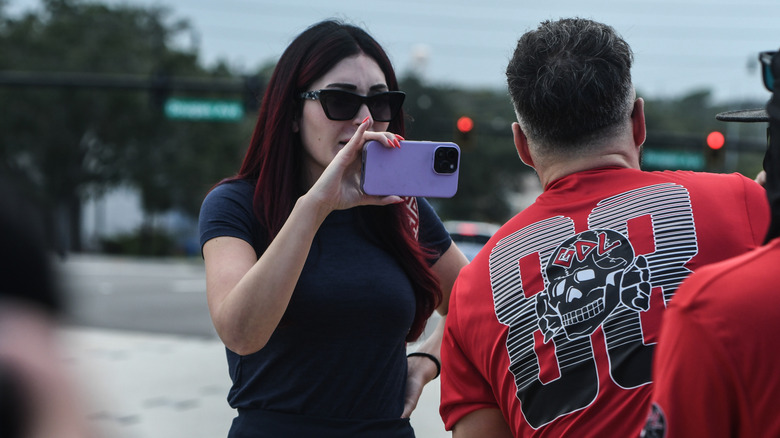 Laura Loomer holding up purple iphone