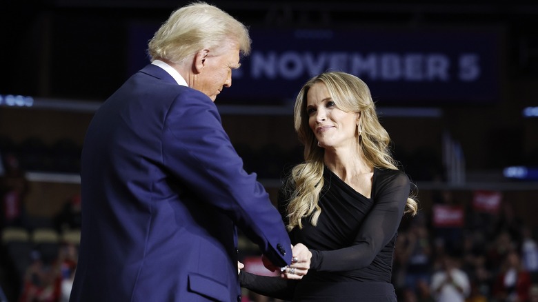 Megyn Kelly and Donald Trump clasping hands onstage