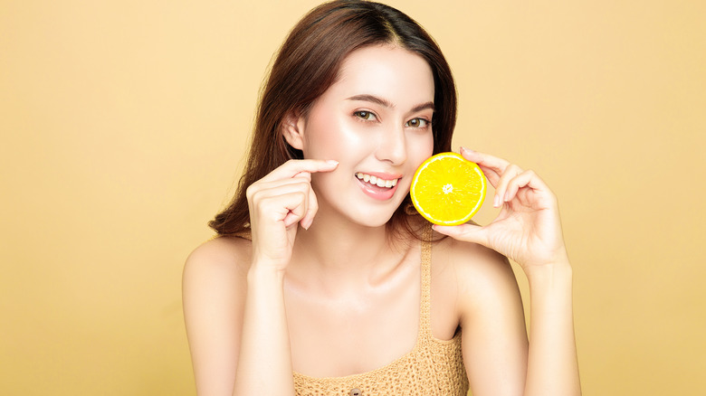 Woman smiling while holding an orange