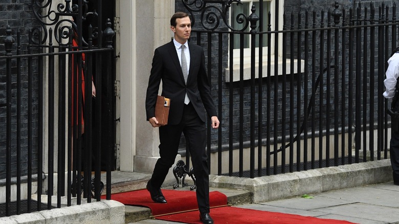 Jared Kushner walking outside in a skinny suit