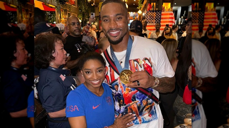 Jonathan Owens wearing Simone Biles' medals