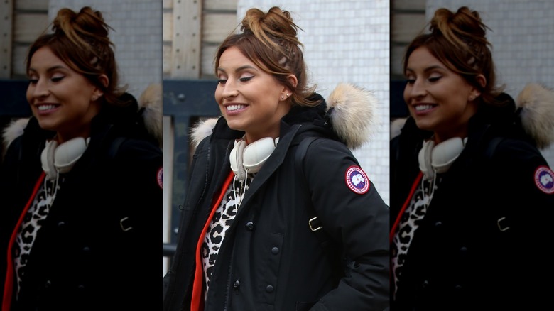 Ferne McCann with bun and visible hair extensions smiling as she leaves ITV Studios