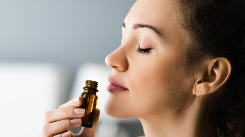 woman smelling a bottle of essential oil