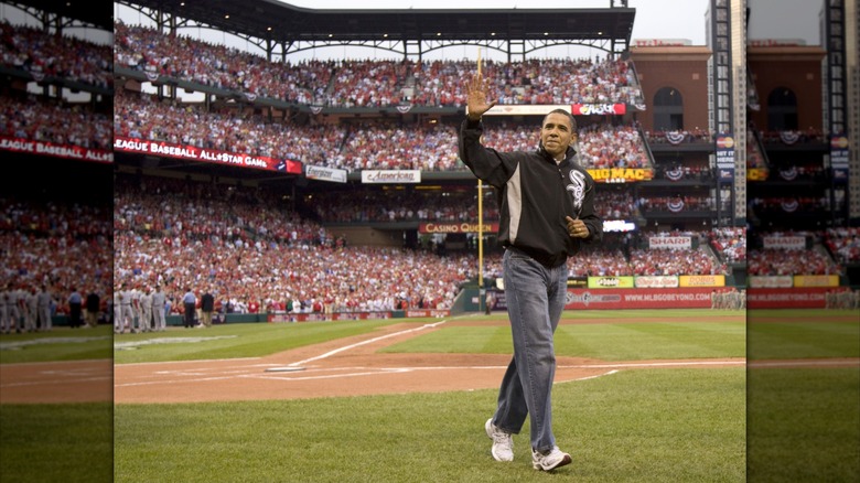 Barack Obama waves to a crowd in a baseball stadium