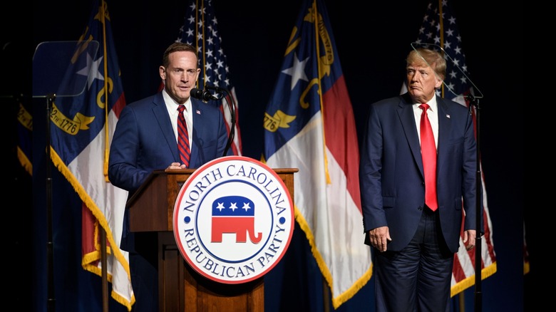 President Donald Trump listens to Ted Budd