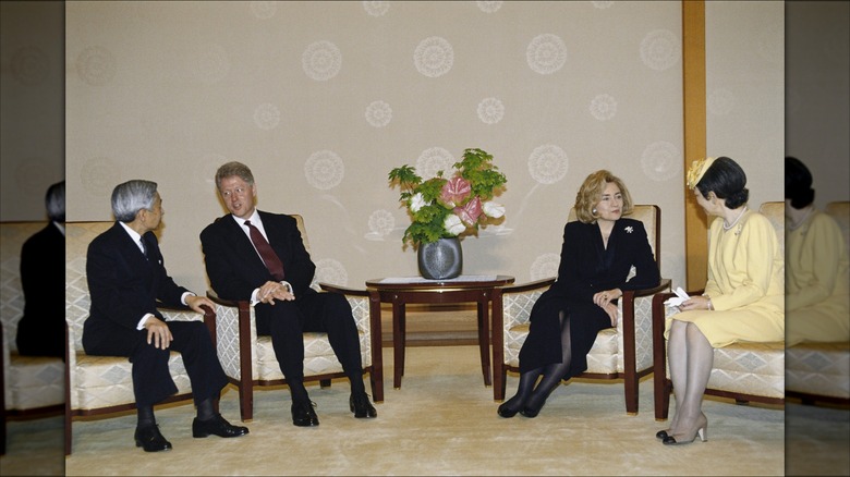 Hillary Clinton sitting with husband Bill and Japanese officials