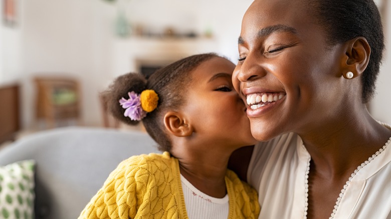 daughter kissing mother on cheek