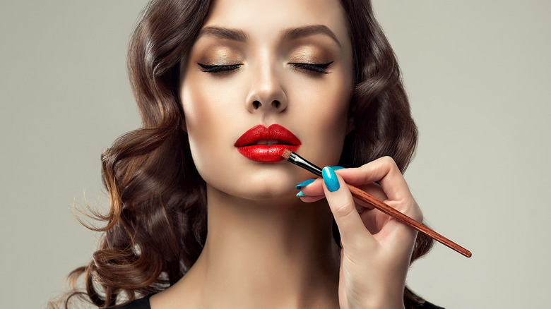 woman applying a classic red lip