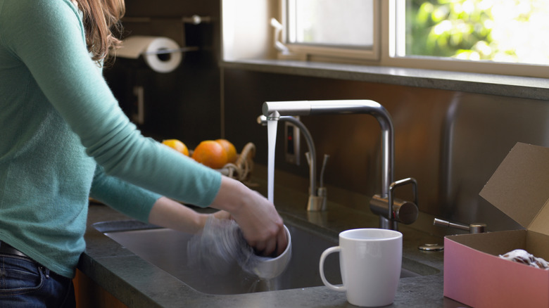 Woman washing coffee mugs