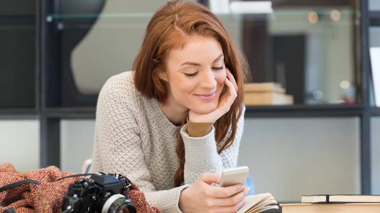 Woman smiling reading text message