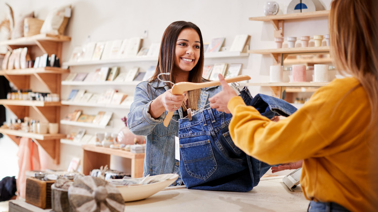 Woman buying jeans in shop