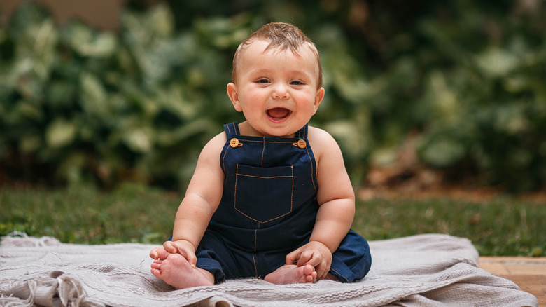 Smiling baby in denim overalls