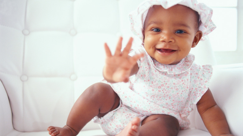 Smiling baby in floral dress and hat