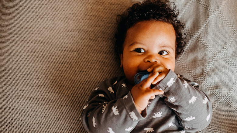 Baby looking sideways with a pacifier