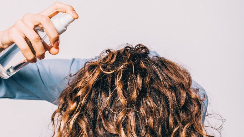 Woman spraying her hair