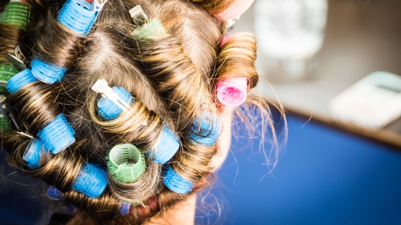 Woman with hair curlers in