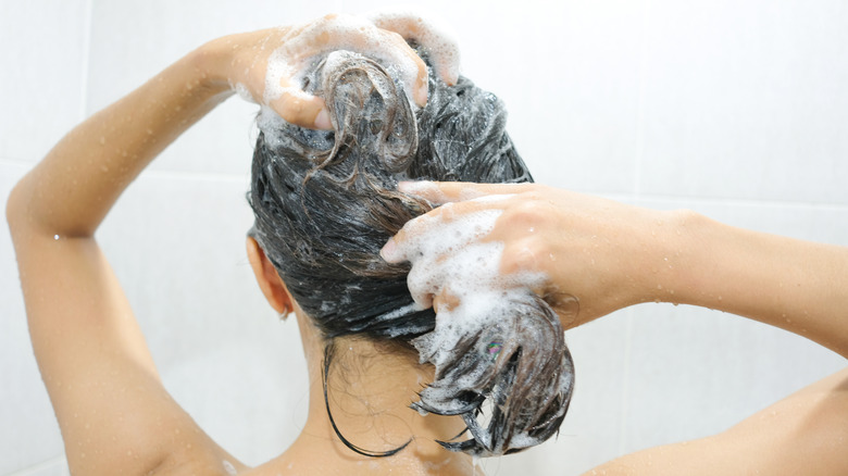 woman washing her scalp in shower