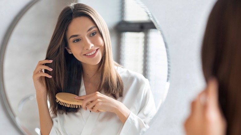 woman with dark hair brushing hair