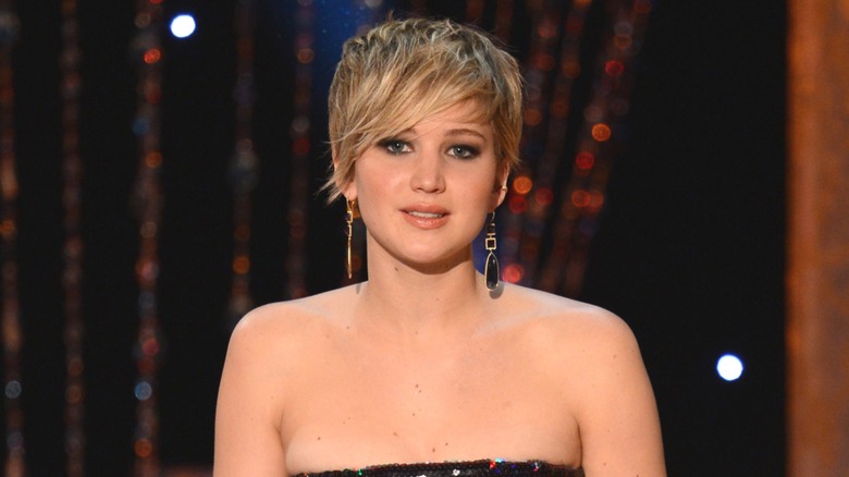 Jennifer Lawrence speaking on stage with pixie cut