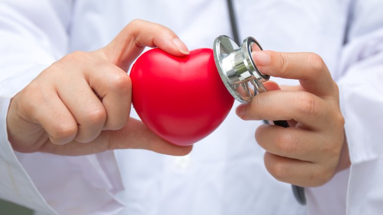 Hands holding a heart and stethescope