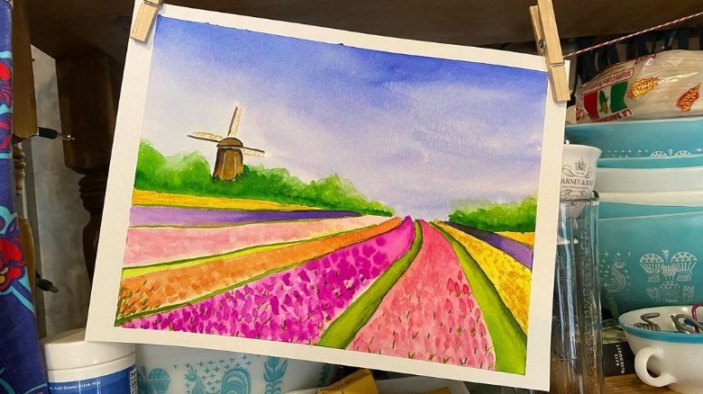 Watercolor painting of flower fields and a windmill