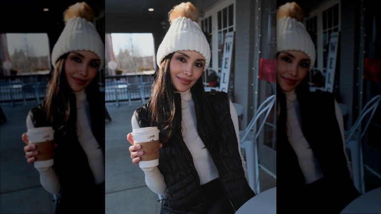 Woman smiling while holding a coffee