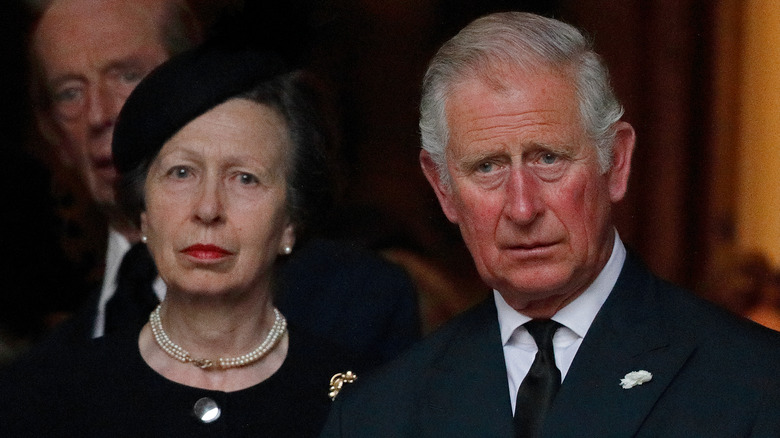 Princess Anne standing next to King Charles