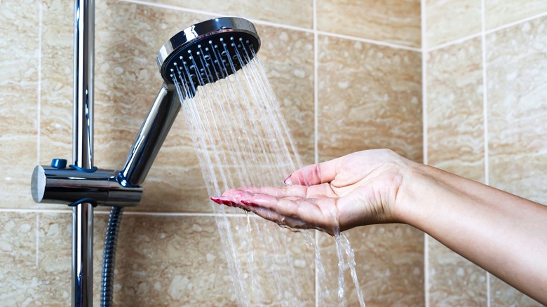 Woman testing the temperature of the shower