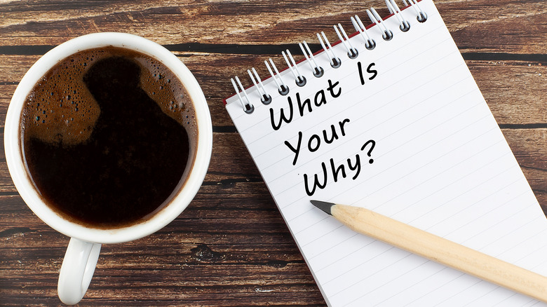 A cup of coffee with a notepad that reads "what is your why?"