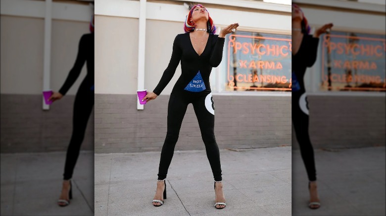 Product image woman in eight ball costume holding a cup and blowing a kiss